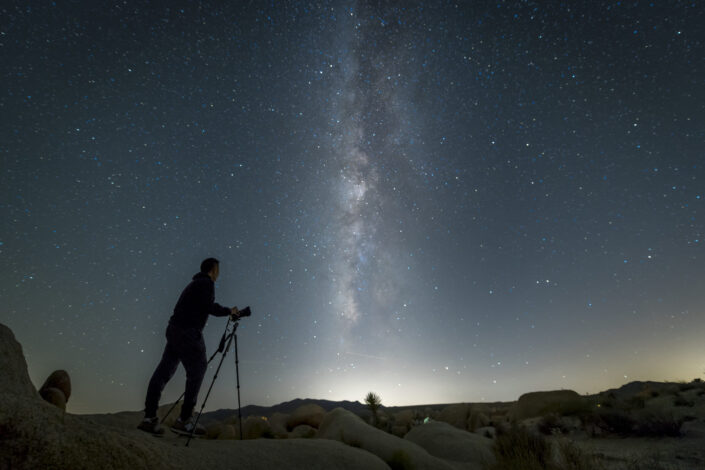A man taking photographs of the starry night sky