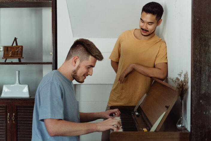 Man playing the piano and the other looking at him