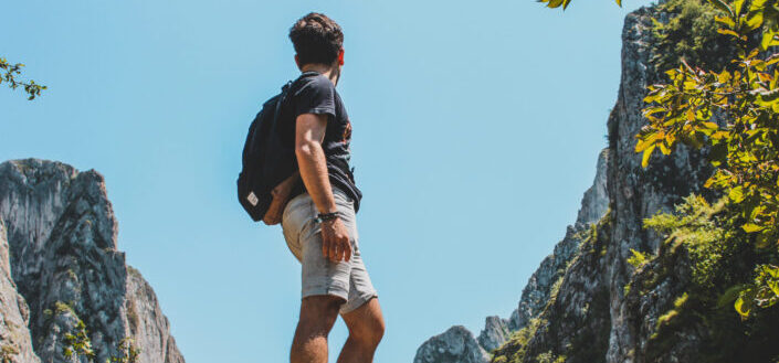 Man with backpack standing on rock